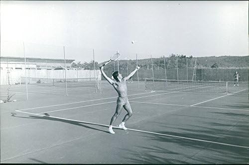 Foto vintage de Sacha Distel jogando um tênis de gramado.