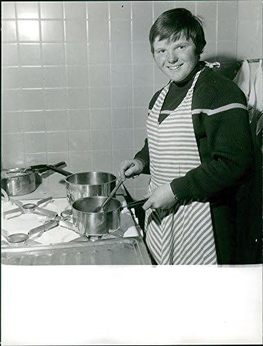 Foto vintage de Isabelle Mir cozinhando na cozinha.